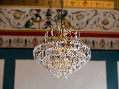 Sul soffitto, da cui pende un elegante lampadario a gocce...